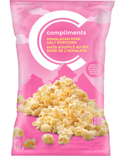 Pink bag of Compliments Himalayan pink salt popcorn mounded over an illustration of the Himalayan mountain range on package.